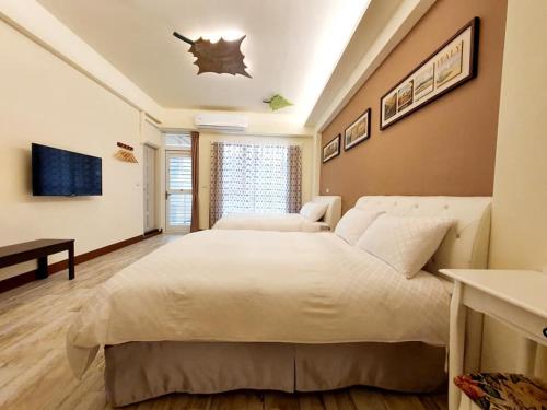 a bedroom with a large white bed in a room at Miao Miao Homestay with Lift in Taitung City