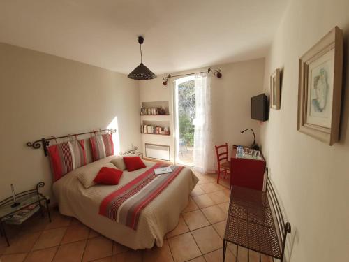 Schlafzimmer mit einem Bett, einem Tisch und einem Fenster in der Unterkunft La Villa du Petit Port in Martigues