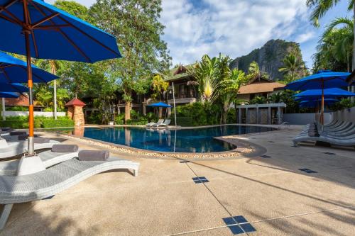 einen Pool mit Liegestühlen und Sonnenschirmen in der Unterkunft Railay Bay Resort & Spa-SHA Extra Plus in Railay Beach