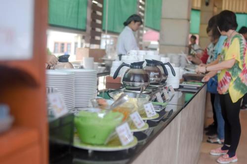 een groep mensen die in een keuken eten klaarmaken bij New Travel Beach Hotel & Resort in Chao Lao Beach