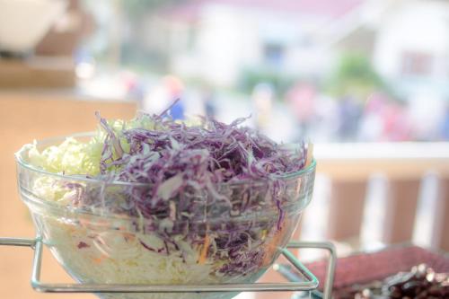 een salade in een glazen kom op een tafel bij New Travel Beach Hotel & Resort in Chao Lao Beach