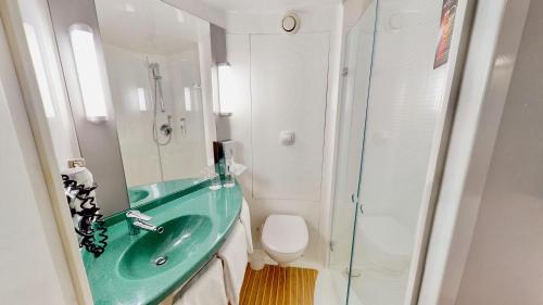 a bathroom with a green sink and a shower at ibis Hotel Köln Airport in Cologne