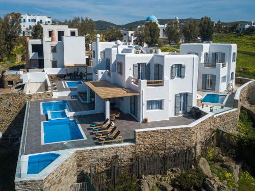une grande maison blanche avec une piscine dans l'établissement NAXIAN SUNSET VILLAS, à Naxos Chora