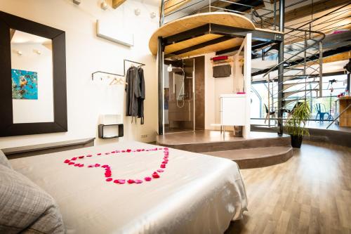 una stanza con un letto bianco con un cuore rosso sopra di Chambres d'hotes Deluxe Jacuzzi Mas de l'Etoile ad Aigues-Mortes