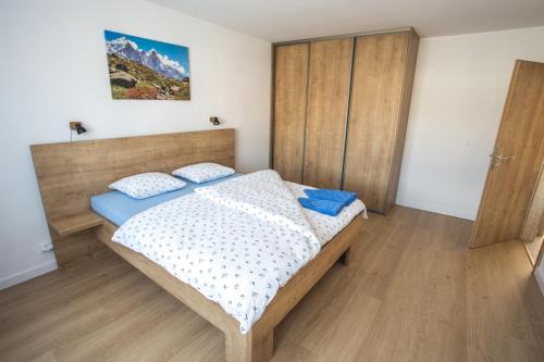 1 dormitorio con 1 cama con cabecero de madera en City apartment Poprad, en Poprad