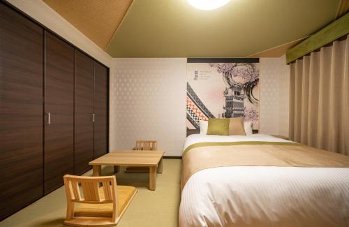 a small bedroom with two beds and a table at Residence Hotel Takayama Station in Takayama