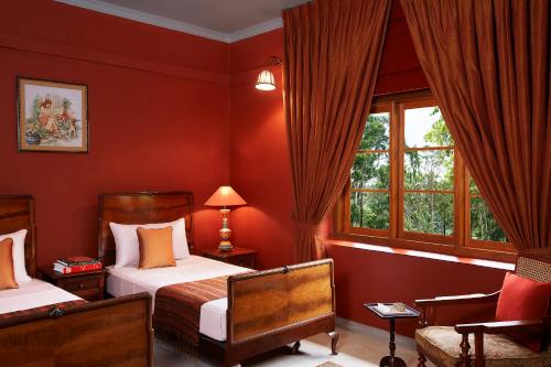 a bedroom with two beds and a chair and a window at Jetwing Warwick Gardens, A Luxury Reserve in Nuwara Eliya