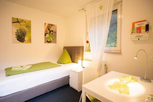 a bedroom with a bed and a table and a window at Hotel Emmerich in Winningen