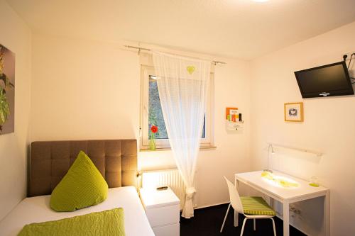 a bedroom with a bed and a desk and a window at Hotel Emmerich in Winningen