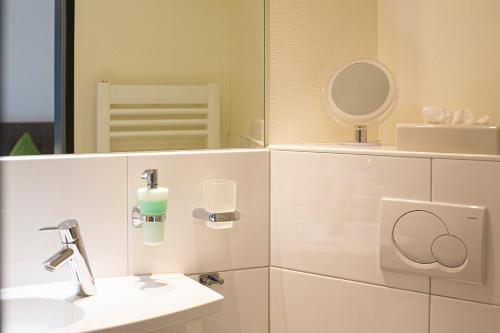 a bathroom with a sink and a mirror at Hotel Emmerich in Winningen