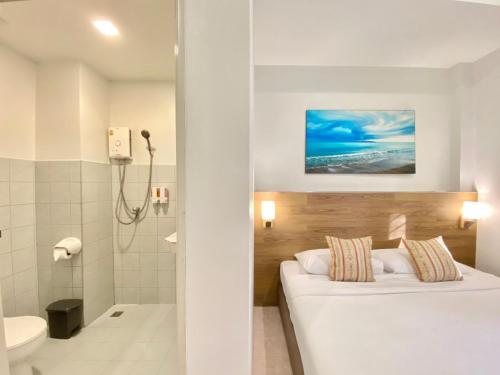 Habitación de hotel con cama y ducha en Pensiri House - SHA Extra Plus en Nai Yang Beach