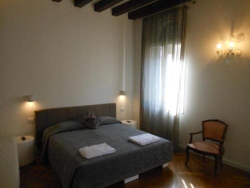 1 dormitorio con 1 cama, 1 silla y 1 ventana en Appartamenti A San Marco, en Venecia