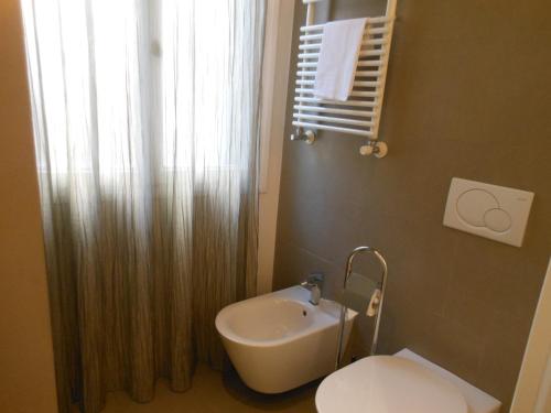 a bathroom with a sink and a toilet and a window at Appartamenti A San Marco in Venice