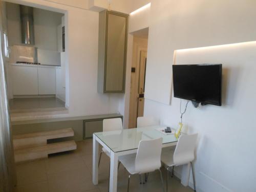 a dining room with a white table and white chairs at Appartamenti A San Marco in Venice