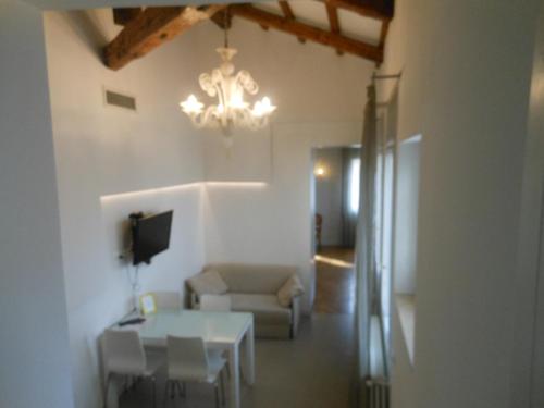 a living room with a table and a chandelier at Appartamenti A San Marco in Venice