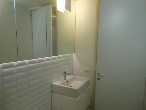 a white bathroom with a sink and a mirror at Appartamenti A San Marco in Venice