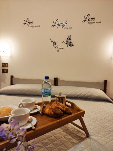 a coffee table with a tray of food on a bed at Hotel Palazzi in Gabicce Mare