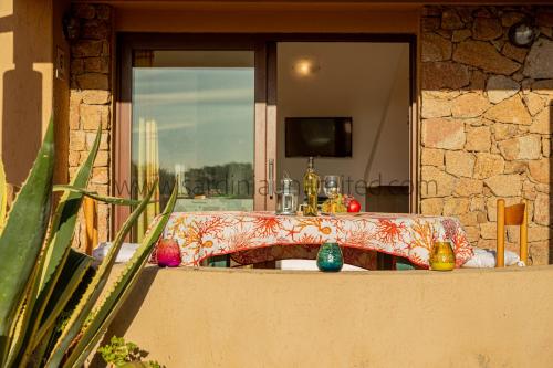 una mesa con adornos coloridos delante de una ventana en Ginepro Arancione, en Li Valcaggi