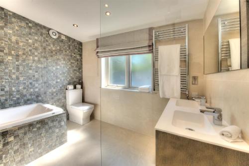 a bathroom with a sink and a tub and a toilet at Isle of Eriska Hotel Spa & Island in Benderloch