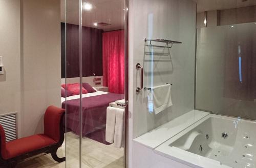 a bathroom with a bath tub and a bedroom at RVHotels Hotel Palau Lo Mirador in Torroella de Montgrí