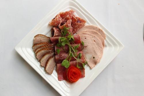 a white plate of food with meat and meats at Thanda Manzi Country Hotel in Centurion