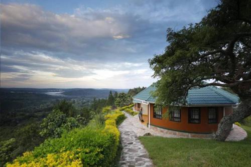 a house on the side of a hill with a tree at Top of The World Lodge in Kikangala