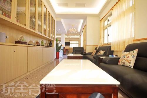 - une salle d'attente avec des canapés et une table dans l'établissement 嚨口秘境觀海民宿The heart of the sea, à Jinning