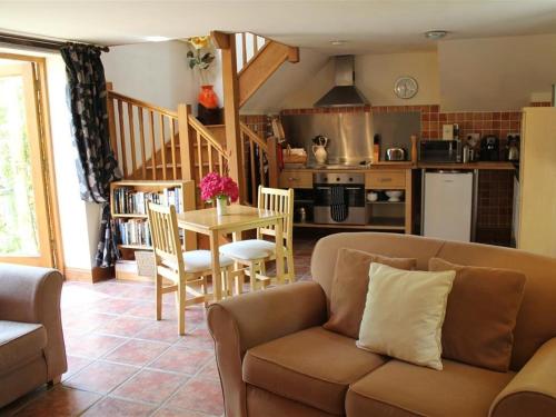 a living room with a couch and a table at The Cider Barn in Flaxley