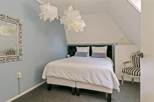 een slaapkamer met een wit bed en 2 stoelen bij Appartement "in de wolken" in Gees in Gees