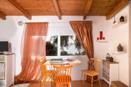 a kitchen with a table and chairs and a window at PaxosBlue Suites & Villas in Gaios
