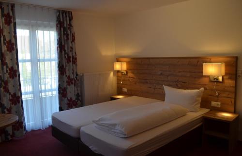 Hotel Zum Goldenen Mann في راشتات: غرفة نوم بسرير ومصباح ونافذة