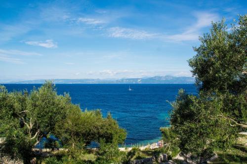 a view of the ocean with a boat in the water at PaxosBlue Suites & Villas in Gaios