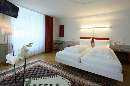 1 dormitorio con 2 camas y ventana grande en Hotel Roter Ochsen en Solothurn