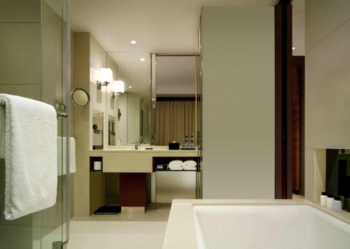 a bathroom with a tub and a sink at Hyatt Regency Hong Kong Tsim Sha Tsui in Hong Kong