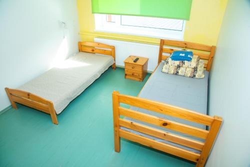 2 camas en una habitación pequeña con suelo azul en Tamsalu Spordikompleksi Hostel, en Tamsalu