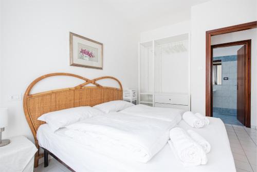 a bedroom with a bed with white sheets and towels at Casa Pelér in Nago-Torbole