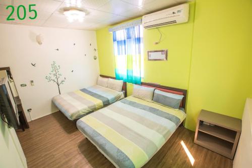 two beds in a room with green walls at Hai Yin in Green Island