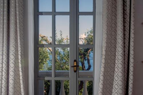 an open window with a view of a tree at PaxosBlue Suites & Villas in Gaios