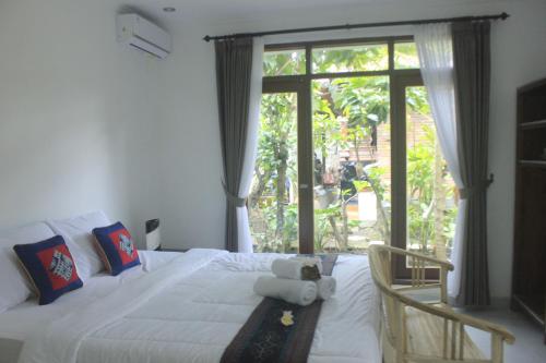 een slaapkamer met een bed met een knuffeldier erop bij Umah De Arlika UBUD in Ubud