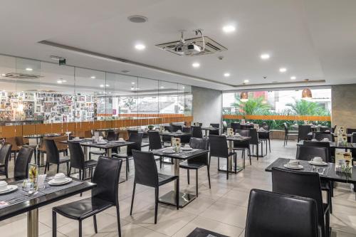 a restaurant with tables and chairs in a room at Citi Hotel Premium Caruaru in Caruaru