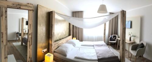 a hotel room with a bed and a window at Hotel Restaurant FIDI in Wolfsthal