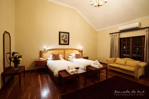 a hotel room with two beds and a couch at Kleinkaap Boutique Hotel in Centurion