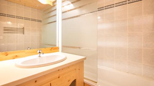 une salle de bain avec un lavabo et une douche dans l'établissement Vacancéole - Résidence La Turra, à Valfréjus