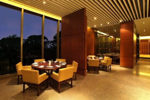 a dining room with a table and chairs and windows at Hyatt Regency Chandigarh in Chandīgarh