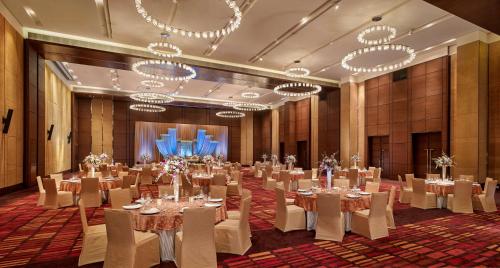 a large room with tables and chairs and chandeliers at Hyatt Regency Chandigarh in Chandīgarh