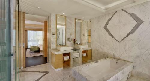 a bathroom with a tub and two sinks and a mirror at Hyatt Regency Chandigarh in Chandīgarh