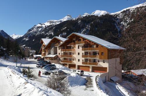 un lodge de ski dans les montagnes avec de la neige au sol dans l'établissement Vacancéole - Résidence La Turra, à Valfréjus