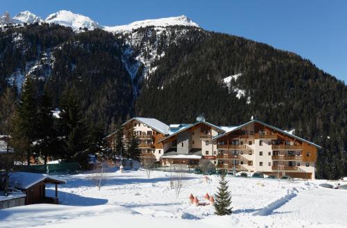 een groot gebouw in de sneeuw voor een berg bij Vacancéole - Résidence La Turra in Valfréjus