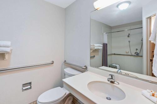 a bathroom with a sink and a toilet and a mirror at La Quinta by Wyndham Mesa Superstition Springs in Mesa