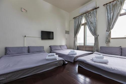 a bedroom with two beds and a flat screen tv at Jia Xiang Lin Guan Hai Homestay in Magong